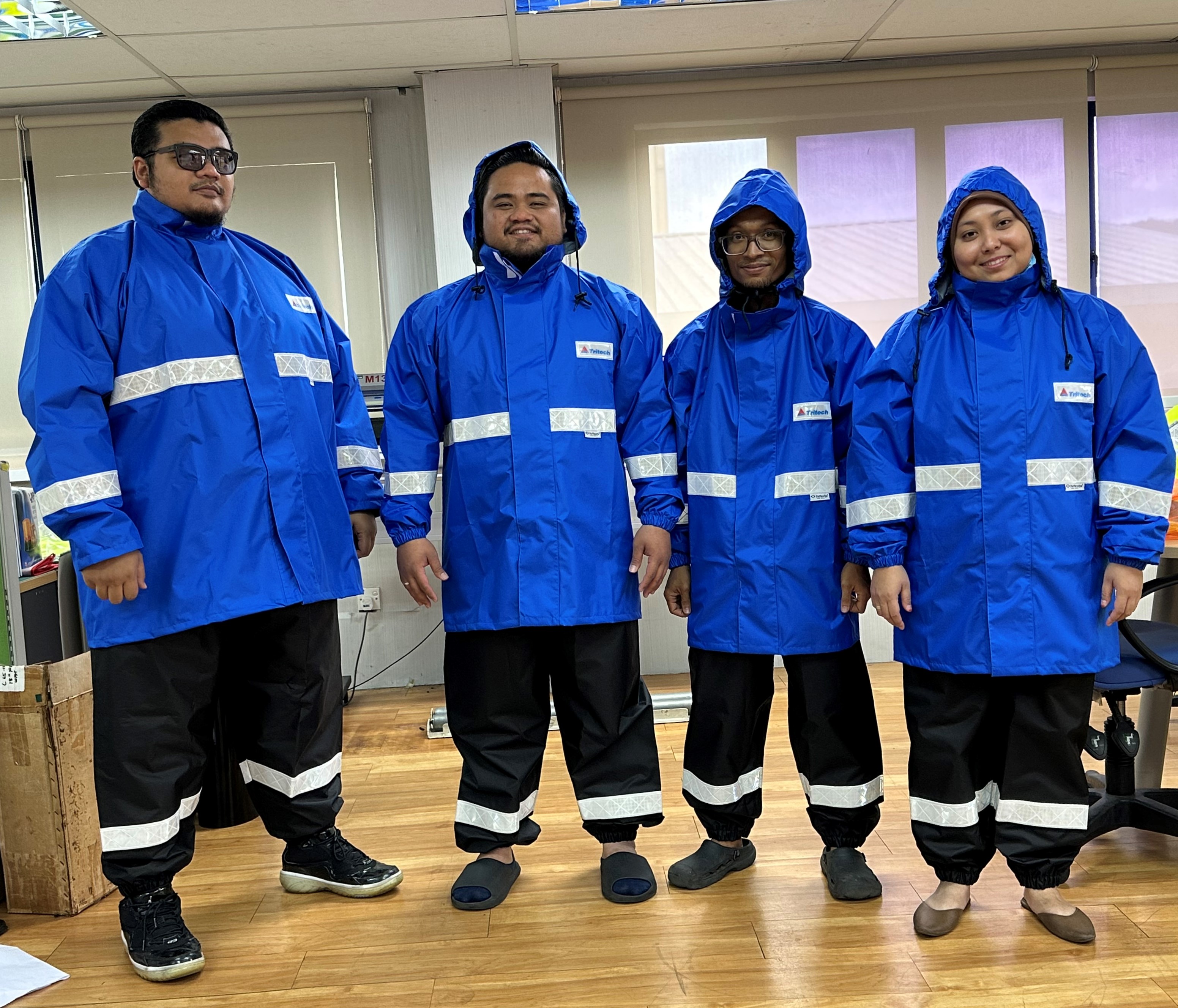 Tritech personnels in reflective raincoat and rainpants